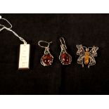 A silver pendant in the form of a miniature ingot with amber brooch and earrings.