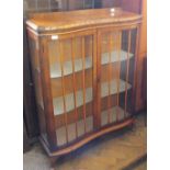 A shaped front glazed display cabinet