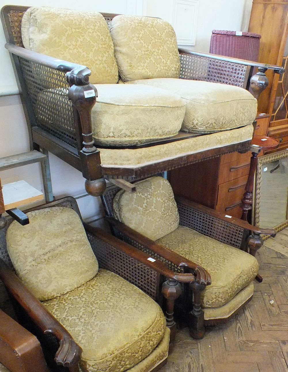 A Bergere oak framed two seat sofa and chairs with carved arms