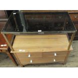 A satinwood chest of two short and one long drawer with ceramic handles and a glass and metal