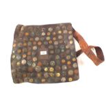 An old leather saddlebag to which are attached numerous Arabic and other coins