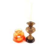 A brass column oil lamp with orange shade