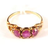 An unmarked gold ring set with three pink stones (one stone is cracked and one has a large chip),