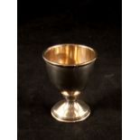 A silver egg cup plus a white metal Worcester Cathedral thimble