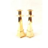 A pair of unusual Arts and Crafts brass candlesticks of six sided tapering form,