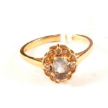 An 18ct gold ring set with blue stone and diamond surround,