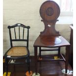 A Regency mahogany hall chair with family crest decoration and a ebonised cane seat child's chair