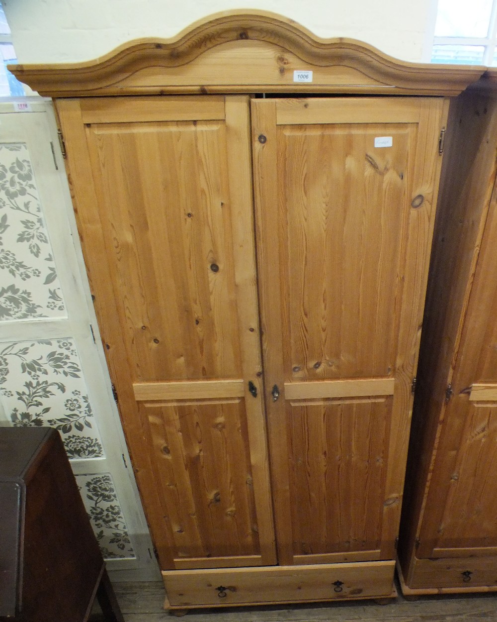 A modern pine two door wardrobe with drawer below