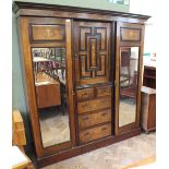 An Edwardian profusely inlaid mahogany double compactum wardrobe