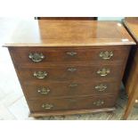 A reproduction veneered chest of four drawers on bun feet