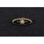 A Victorian yellow metal onyx set mourning brooch with star pattern set with seed pearls (two