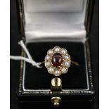 A 9ct gold ring set with cabochon red stone surrounded by pearls,
