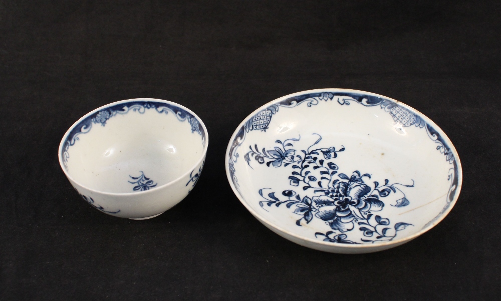A Lowestoft floral tea bowl and saucer (light cracks to both)