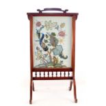 A mahogany woolwork floral fire screen