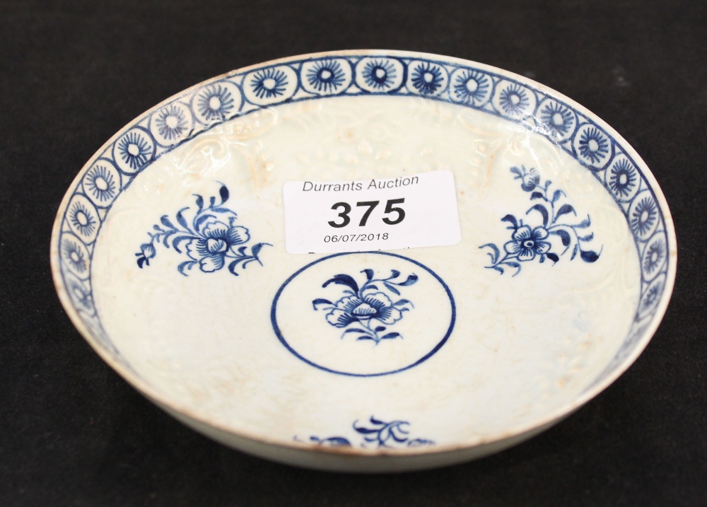 A Lowestoft Hughes type relief moulded floral saucer (light rim cracks and restoration)