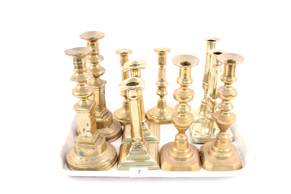 Five pairs of Georgian and Victorian brass candlesticks,