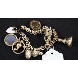 A yellow metal bracelet with 9ct gold heart shaped padlock clasp hung with various charms,