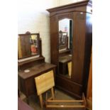 An Edwardian oak single mirror door wardrobe with drawer below,