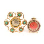 A brass easel clock set with green cabochon stones plus one other with red enamel dial