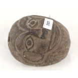 A tribal carved stone weight with face carving,