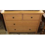 A modern faux pine chest of two short and two long drawers