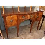 A serpentine front sideboard with brass handles and ivory escutcheons