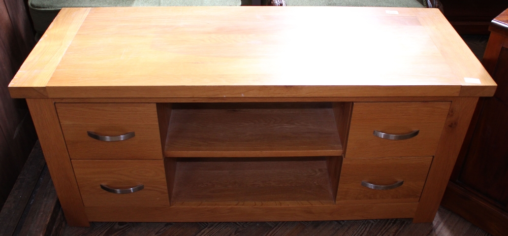 A modern oak TV stand with four drawers