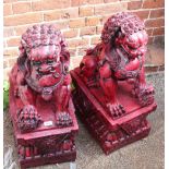 A pair of red composite resin Dogs of Fo garden statues