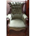 A Victorian carved mahogany buttonback green velvet upholstered armchair