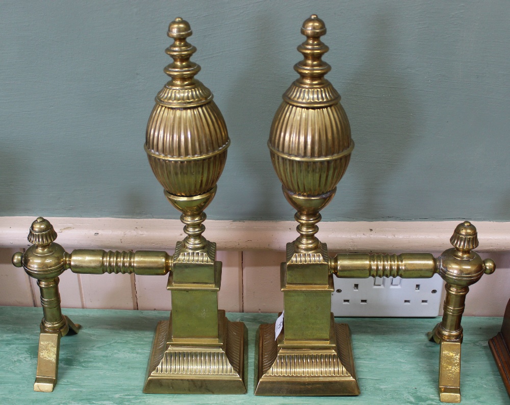 An impressive pair of large 19th Century brass fire dogs with fluted decoration,