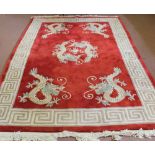 A Chinese red ground carpet with dragon decoration,