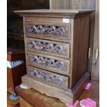 A chest of four drawers with carved decoration