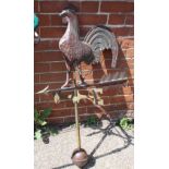 A brass weather vane with cockerel standing on an arrow