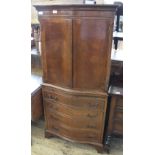 A reproduction Serpentine front drinks cabinet in the form of a chest of drawers with cupboard top