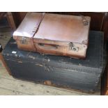 A large black travelling trunk and a vintage suitcase