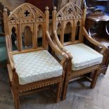 A pair of Gothic style carved pine armchairs