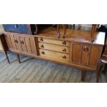 A retro 1970's sideboard with three drawers and three cupboard doors on tapered legs