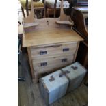 An Edwardian satinwood dressing chest of four drawers and a vintage suitcase