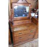 An Edwardian oak dressing chest of three long drawers with mirror back top