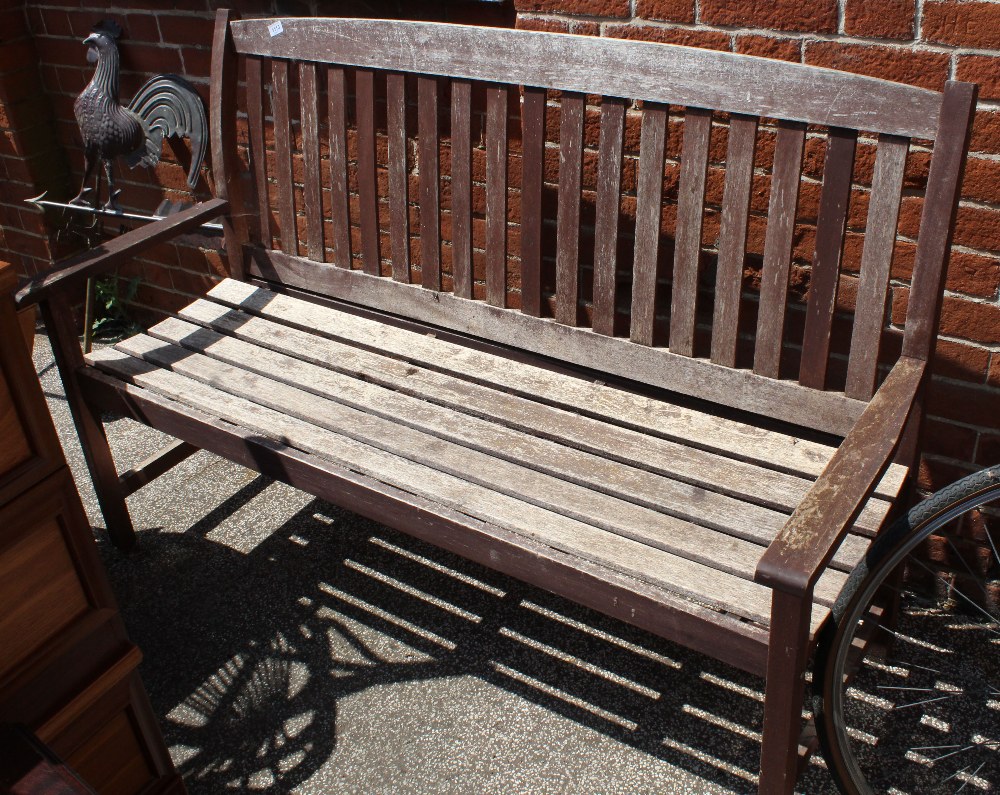 A large weathered wooden garden bench