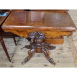 A 19th Century carved burr walnut games table on tripod base with quatrefoil supports