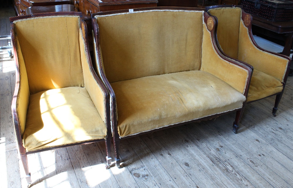 An Edwardian mahogany salon suite with mustard velvet upholstery and inlaid decoration comprising a