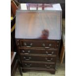 A narrow reproduction mahogany bureau