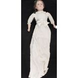 A dressed doll with porcelain head and limbs (leg repair)