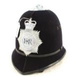 A Police helmet bearing Metropolitan Police insignia plate