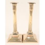A pair of 18th Century brass candlesticks with part fluted cylindrical columns and beaded square