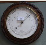 A circular carved mahogany barometer