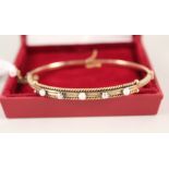 A gold bangle set with pearls and diamonds (marks rubbed)