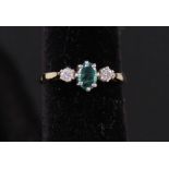 A three stone emerald and diamond ring, marks rubbed,