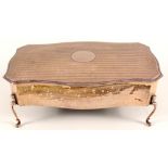 A large silver box of shaped legs with engine turned decoration to lid,